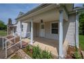 Covered front porch featuring white columns and railings, stone accents, and space for outdoor enjoyment at 1501 Nc Hwy 73 Hwy, Iron Station, NC 28080