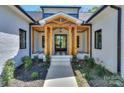 Inviting front entrance with wooden accents, black and white tile, and a stylish glass door at 153 High Hills Dr, Mooresville, NC 28117