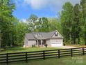 Attractive one story home with an attached garage, set in a serene, wooded location with a black wooden fence at 2127 Cedar Rd, York, SC 29745
