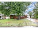 Ranch style brick home with a front yard shaded by a mature tree at 2218 W Fifth Ave, Gastonia, NC 28052