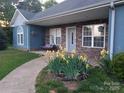 Inviting front porch with a swing, stone accents, well-manicured flowerbeds, and a welcoming entrance at 4330 Goodman Lake Rd, Salisbury, NC 28146