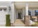 Inviting front porch with stone column bases and a decorative wreath on the front door at 4607 Walking Path Dr, Waxhaw, NC 28173