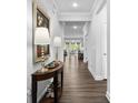 Hallway with dark wood floors leading to the living area, complemented by elegant lamps and decor at 4607 Walking Path Dr, Waxhaw, NC 28173