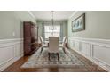 Formal dining room with wainscoting, stylish rug, and elegant lighting, perfect for entertaining guests at 5050 Kinross Ln, Indian Land, SC 29707