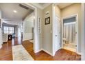Inviting hallway featuring hardwood floors and elegant trim leading to living areas and a bathroom at 5050 Kinross Ln, Indian Land, SC 29707