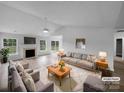 Bright living room with fireplace, ceiling fan, light gray sofa and chairs on an area rug at 508 Danfield Dr, Clover, SC 29710