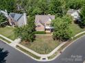 Aerial shot of a charming brick home nestled among lush trees in a friendly neighborhood at 6904 Mordred Ln, Charlotte, NC 28277