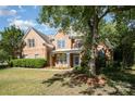 Beautiful brick home featuring well-kept lawn, front flower boxes, and mature trees at 6904 Mordred Ln, Charlotte, NC 28277