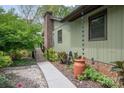 The side of the house features a brick chimney, a charming rain chain, and decorative plants at 78 N Scalybark Trl, Concord, NC 28027