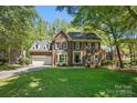 Charming two-story brick home with manicured lawn and mature trees, showcasing classic architectural details at 902 Hoke Trl, Cramerton, NC 28032