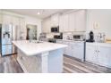 Beautiful kitchen with white cabinets, a large island with quartz countertops, and stainless steel appliances at 11616 Solstice Way, Huntersville, NC 28078