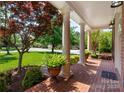 Charming front porch with brick flooring, stately columns, and manicured landscaping at 12122 Camden Trail Ct, Charlotte, NC 28277