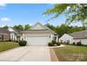 View of the side and front of home featuring an attached garage, manicured lawn, and mature trees at 1488 River Bend Blvd, Fort Mill, SC 29707