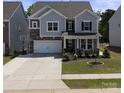 Charming two-story home with stone accents, a welcoming front porch, and well-maintained landscaping at 184 Tetcott St, Mooresville, NC 28115