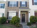 Charming two-story townhome with brick facade, black shutters, and a well-manicured front yard at 1960 Aston Mill Pl, Charlotte, NC 28273