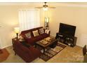 Bright living room featuring neutral walls, ceiling fan, and comfortable seating arrangement at 1960 Aston Mill Pl, Charlotte, NC 28273