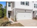 Close-up of the white garage door, gray siding, and front door of this inviting townhome at 2340 Belterra Dr, Charlotte, NC 28216