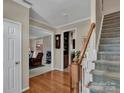 Bright foyer featuring hardwood floors, staircase, and an open view to living room at 237 Walnut Point Dr, Matthews, NC 28105