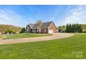 Sprawling brick home featuring an expansive driveway, lush lawn, and mature trees enhancing its curb appeal at 2610 Flagstone Ct, Shelby, NC 28152