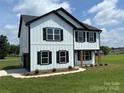 Beautiful two-story home with white siding, black trim, complemented by professionally landscaped yard at 3012 Isle Ln, Monroe, NC 28110