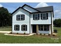 Charming two-story home featuring white siding, black trim, and a welcoming front porch at 3012 Isle Ln, Monroe, NC 28110