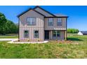 Charming home featuring vertical siding, black trim, and a well-manicured lawn in a serene setting at 3012 Isle Ln, Monroe, NC 28110