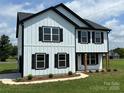 Beautiful two-story home with white siding, black trim, complemented by professionally landscaped yard at 3012 Isle Ln, Monroe, NC 28110