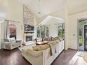 Bright living room featuring a brick fireplace, vaulted ceilings, and hardwood floors at 3017 Planters Walk Ct, Charlotte, NC 28210