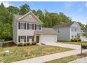 Two-story home featuring neutral siding and a driveway leading to an attached two-car garage at 303 Landis Oak Way, Landis, NC 28088