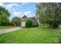 This is a charming home with a well-maintained lawn, a driveway, and an attached garage on a sunny day at 3606 White Swan Ct, Indian Trail, NC 28079