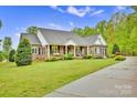 Stately brick home with a welcoming front porch, lush lawn, and manicured landscaping at 3871 Cool Branch Dr, Maiden, NC 28650