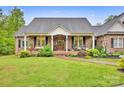 Inviting brick home with a charming front porch and meticulously landscaped garden at 3871 Cool Branch Dr, Maiden, NC 28650