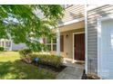 Inviting front entrance with a covered porch, lush landscaping, and a visible security system for added peace of mind at 4315 Barnside Ln, Charlotte, NC 28216