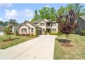 Attractive home with well-kept lawn, stone accents, and a long driveway leading to a two car garage at 513 Sandbar Pt, Lake Wylie, SC 29710