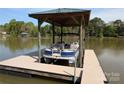 Covered boat dock features a blue pontoon on a sunny lake with treelined backdrop at 6778 Emerald Isle Dr, Sherrills Ford, NC 28673