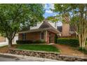 Brick home's side view featuring mature trees, tidy landscaping, and a charming brick gate entrance at 7502 Hurstbourne Green Dr, Charlotte, NC 28277