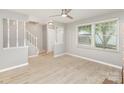 Bright living room with new flooring, stairway, large window, and neutral paint colors at 7507 Holly Grove Ct, Charlotte, NC 28227