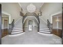 Grand foyer with a dual staircase, chandelier, and light tile flooring at 802 Capington Ln, Waxhaw, NC 28173