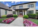 Elegant front entrance with a double door, covered porch, and blooming flower beds at 802 Capington Ln, Waxhaw, NC 28173