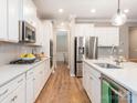Bright, modern kitchen with white cabinets, stainless steel appliances, and hardwood flooring at 8065 Cornhill Ave, Charlotte, NC 28277