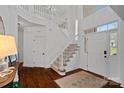 Bright, spacious foyer with high ceilings, hardwood floors, and a staircase with white railings at 8600 Glade Ct, Huntersville, NC 28078