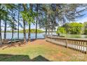 Picturesque waterfront backyard with mature trees, lush grass, and a private wooden dock at 921 Northeast Dr # 39, Davidson, NC 28036