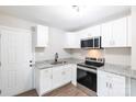 Modern white kitchen featuring stainless steel appliances, granite countertops, and wood-look flooring at 1011 Rickert St, Statesville, NC 28677
