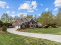 Expansive brick home boasting a large lawn, mature trees, and a long driveway at 110 Devonshire Ln, Salisbury, NC 28146