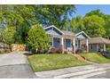 Charming blue house with a quaint porch, swing, brick accents, and long driveway at 1716 Wickford Pl, Charlotte, NC 28203