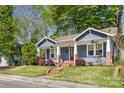 Charming blue house with a quaint porch, swing, brick accents, and well-maintained lawn at 1716 Wickford Pl, Charlotte, NC 28203