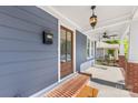 Charming front porch with brick base, hanging lantern, ceiling fan, and a wooden front door at 1716 Wickford Pl, Charlotte, NC 28203