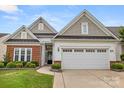 Beautiful home showcasing a brick and siding exterior, well-kept landscaping, and spacious two-car garage at 20135 Dovekie Ln, Fort Mill, SC 29707