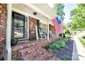 Inviting front porch with rocking chairs and an American flag, framed by a brick facade at 212 Brookwood Dr, Salisbury, NC 28146