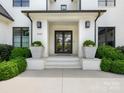 Grand entrance featuring a classic door with decorative planters and meticulously manicured landscaping at 2343 Vernon Dr, Charlotte, NC 28211